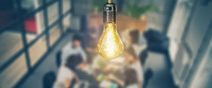 Lightbulb hanging from ceiling above board room table